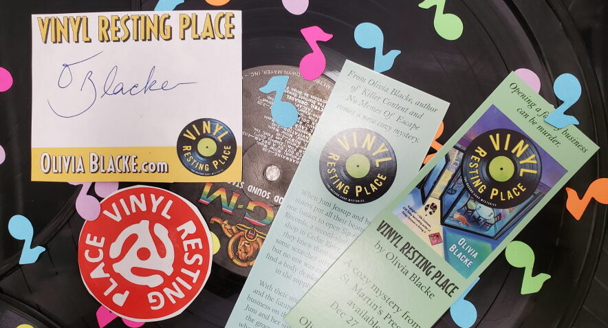 Signed bookplate, sticker, and bookmark (front and back) on top of a record covered in musical note-shaped graffiti